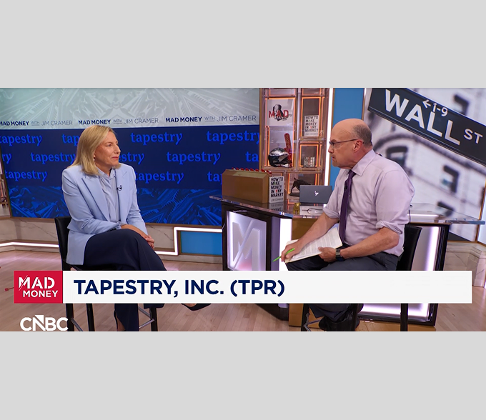 Interviewer and female executive in luxury boutique interview; on-screen text reads Tapestry, Inc. (TPR)